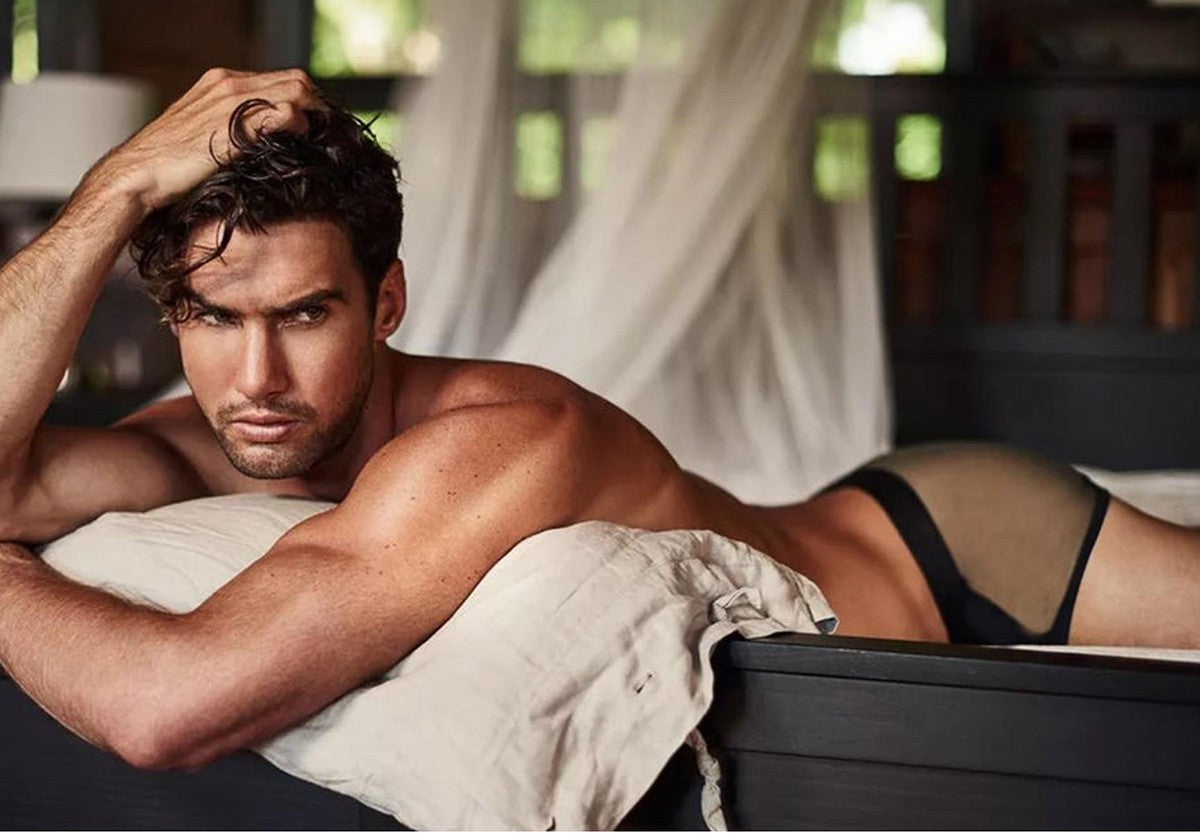 Man in black Arjen Kroos underwear relaxing on a bed