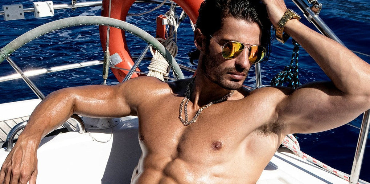 Man in mirrored sunglasses relaxing on a sailing boat at sea