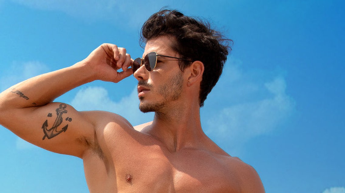 Man in sunglasses under a bright blue summer sky